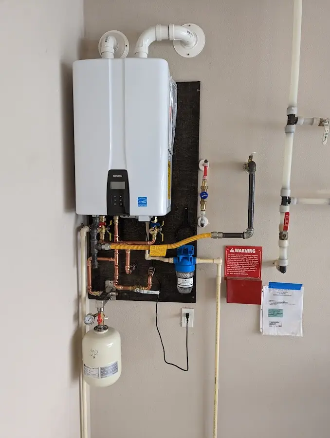 Professional plumber installing copper piping in a French Camp home